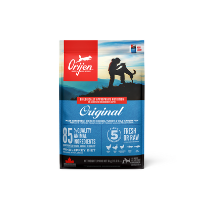 A package of ORIJEN Original Dog Food with a picture of a dog and a person on a mountainous landscape.